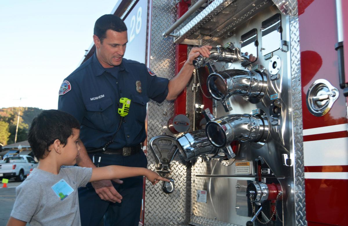 Kid learning about fire engines at National Night Out.