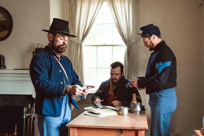 Reenactors in one of the fort homes around a dinner table