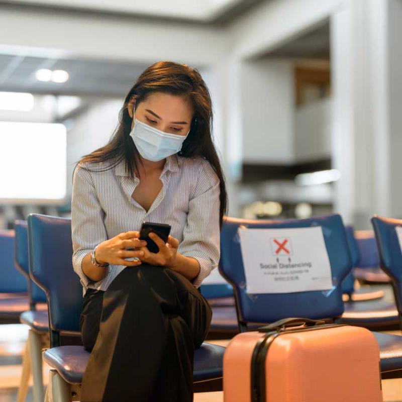 Woman wearing a mask in an airport waiting room.