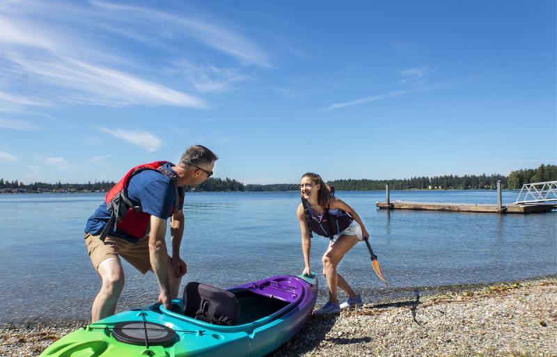 Father and daughter putting a kayak in at American Lake (Lakewood, WA)