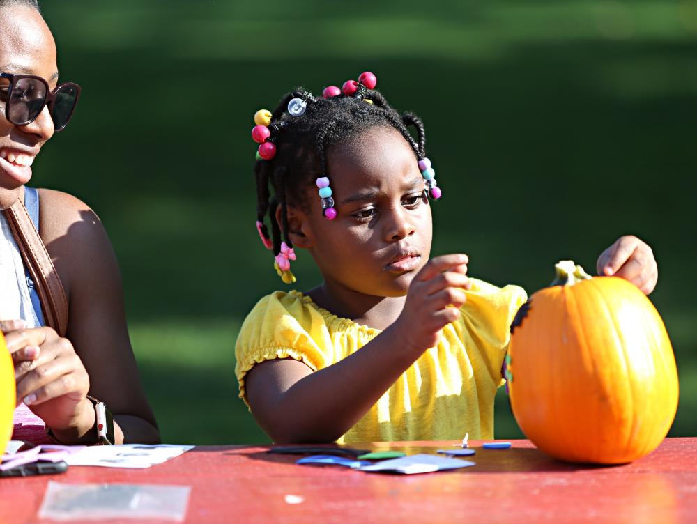 Little girl painting a pumpkin at Truck and Tractor Day.